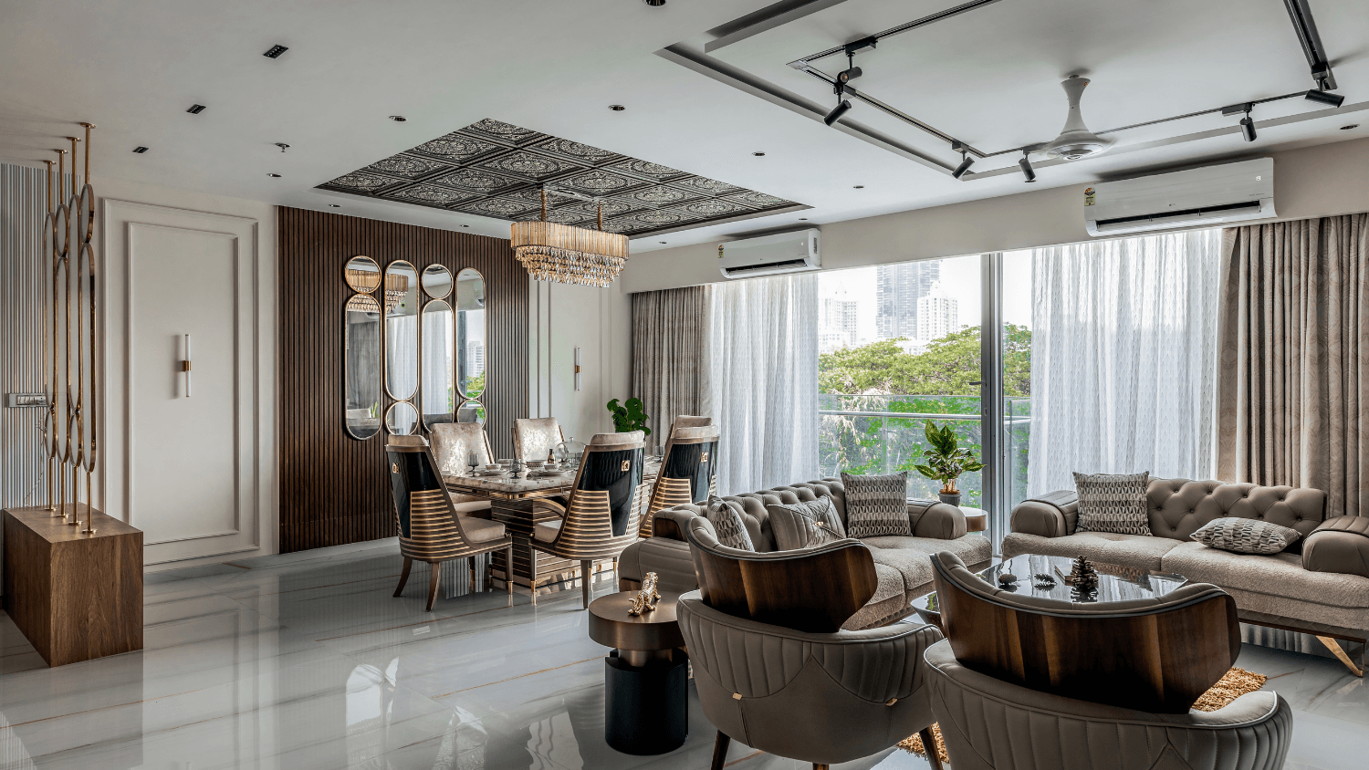 Luxury living and dining room with a statement chandelier and gold-accented furniture